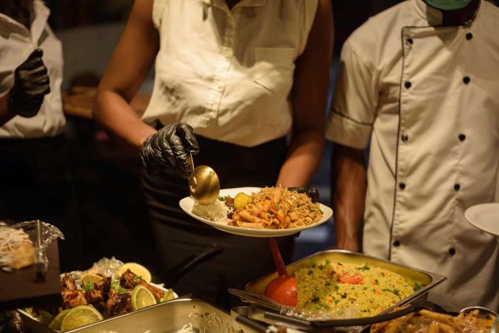 Catering service in Enugu, Nigeria with delicious buffet offerings served by staff.
